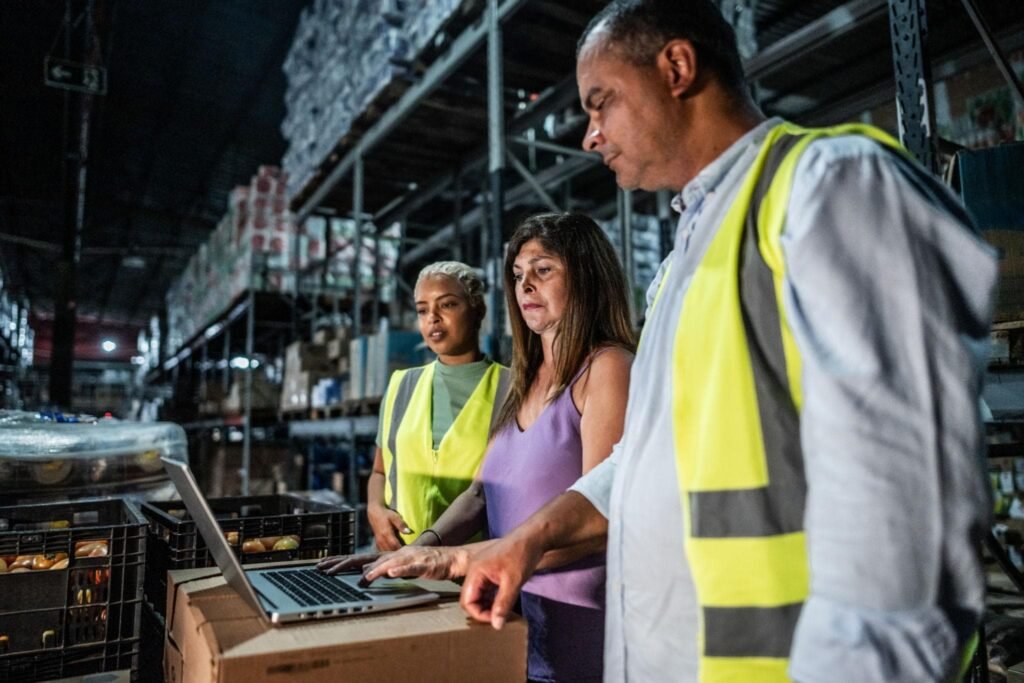 Business partners meeting at a Brazilian distribution warehouse to discuss commercial cooperation and product distribution.